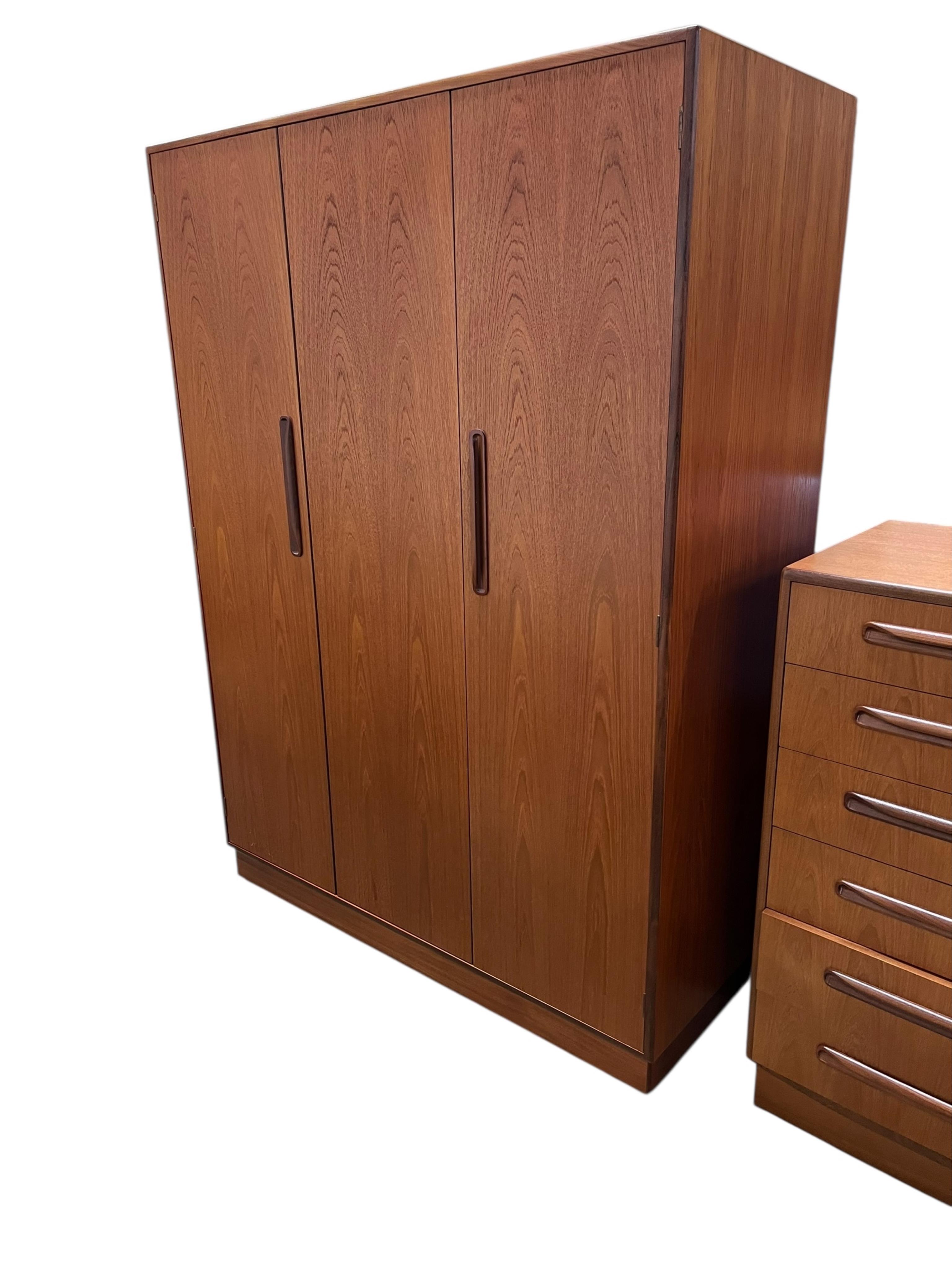 A mid century G Plan Fresco teak bedroom suite comprising a three door wardrobe, a two door wardrobe, two six drawer chests, dressing table, headboard and a pair of bedside chests